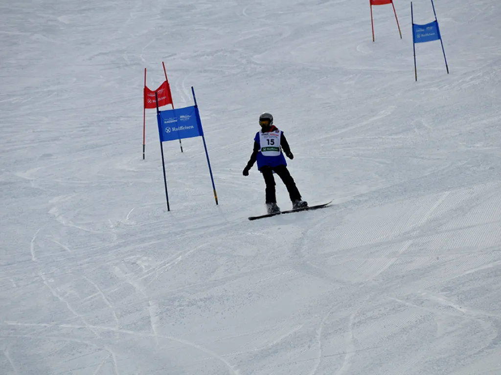 Snowboarder fährt zwischen rotem und blauem Tor hindurch.